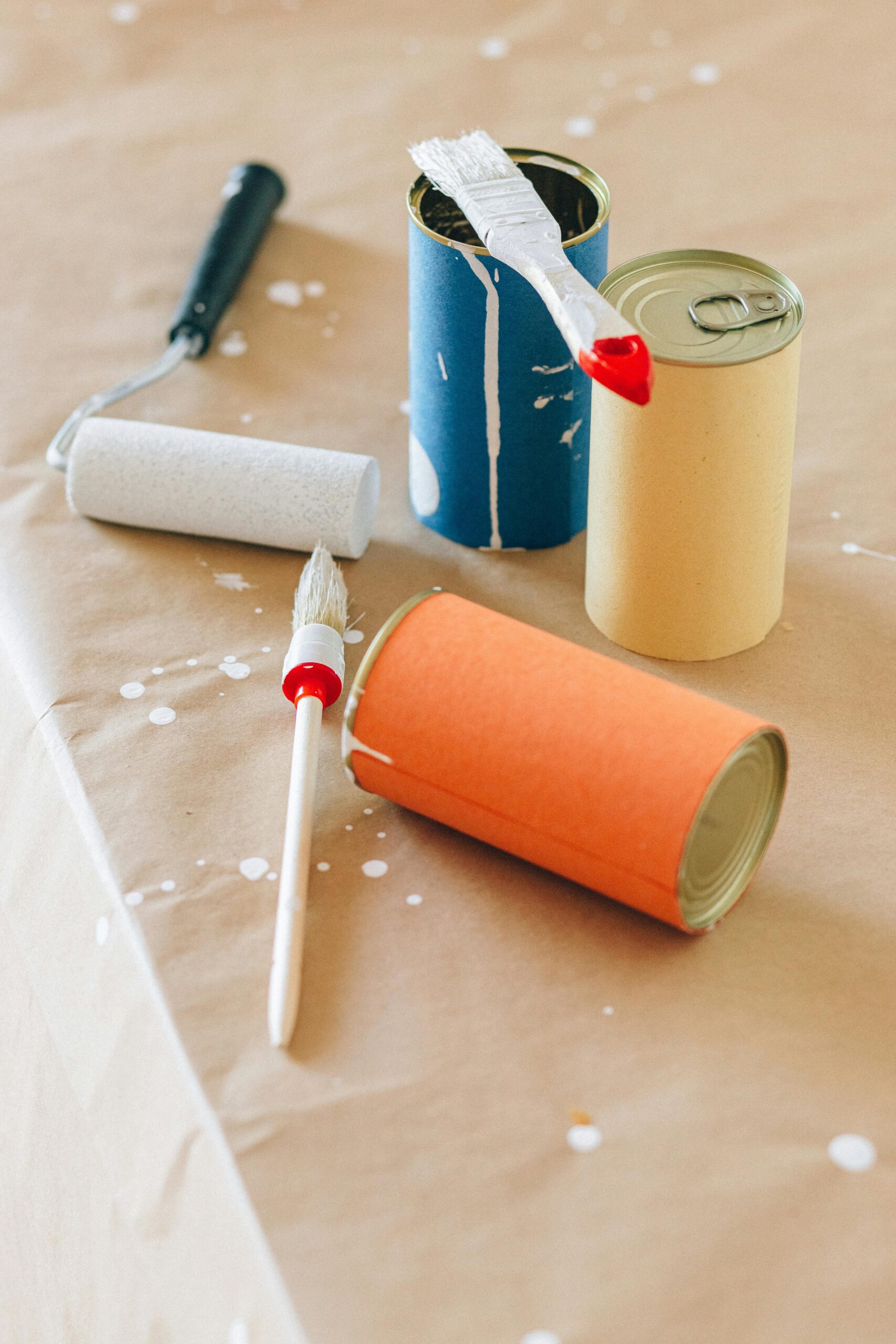 Creative upcycled paint cans with brushes and rollers, perfect for art and DIY projects.