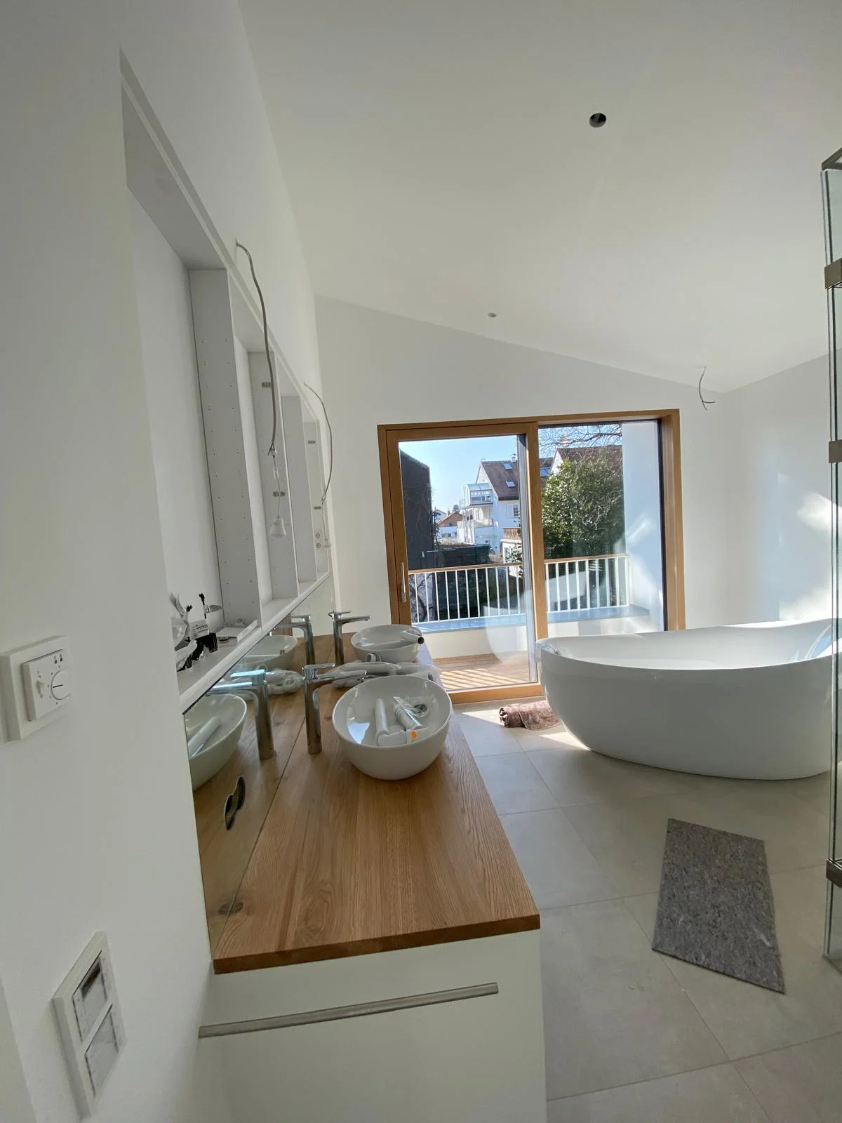 Helle Wandflächen und Tageslicht in einem Badezimmer mit freistehender Badewanne