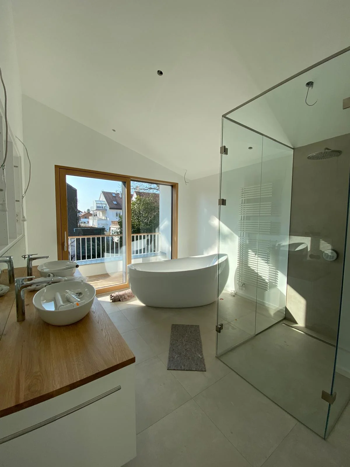 Helles Badezimmer mit ruhigen weißen Wandflächen und freistehender Badewanne