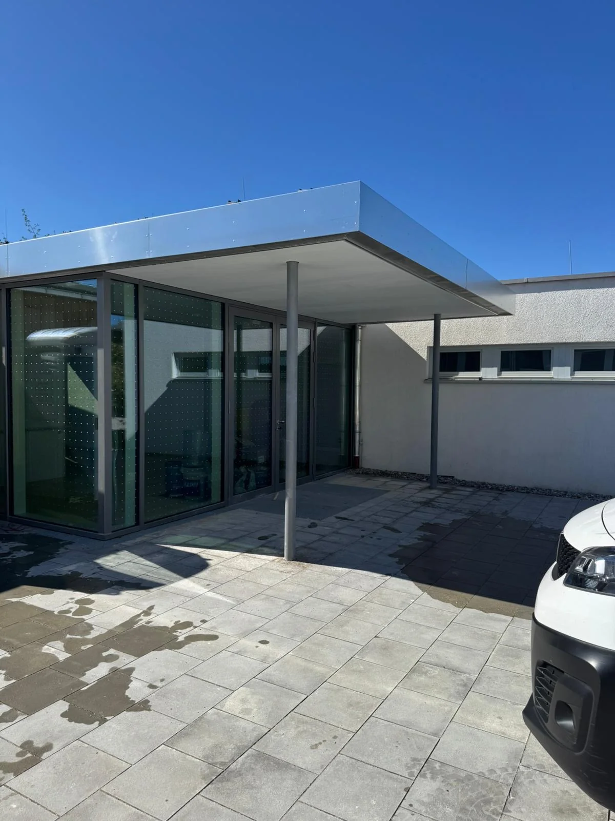 Moderne helle Fassade mit Glasfront und flachem Dach