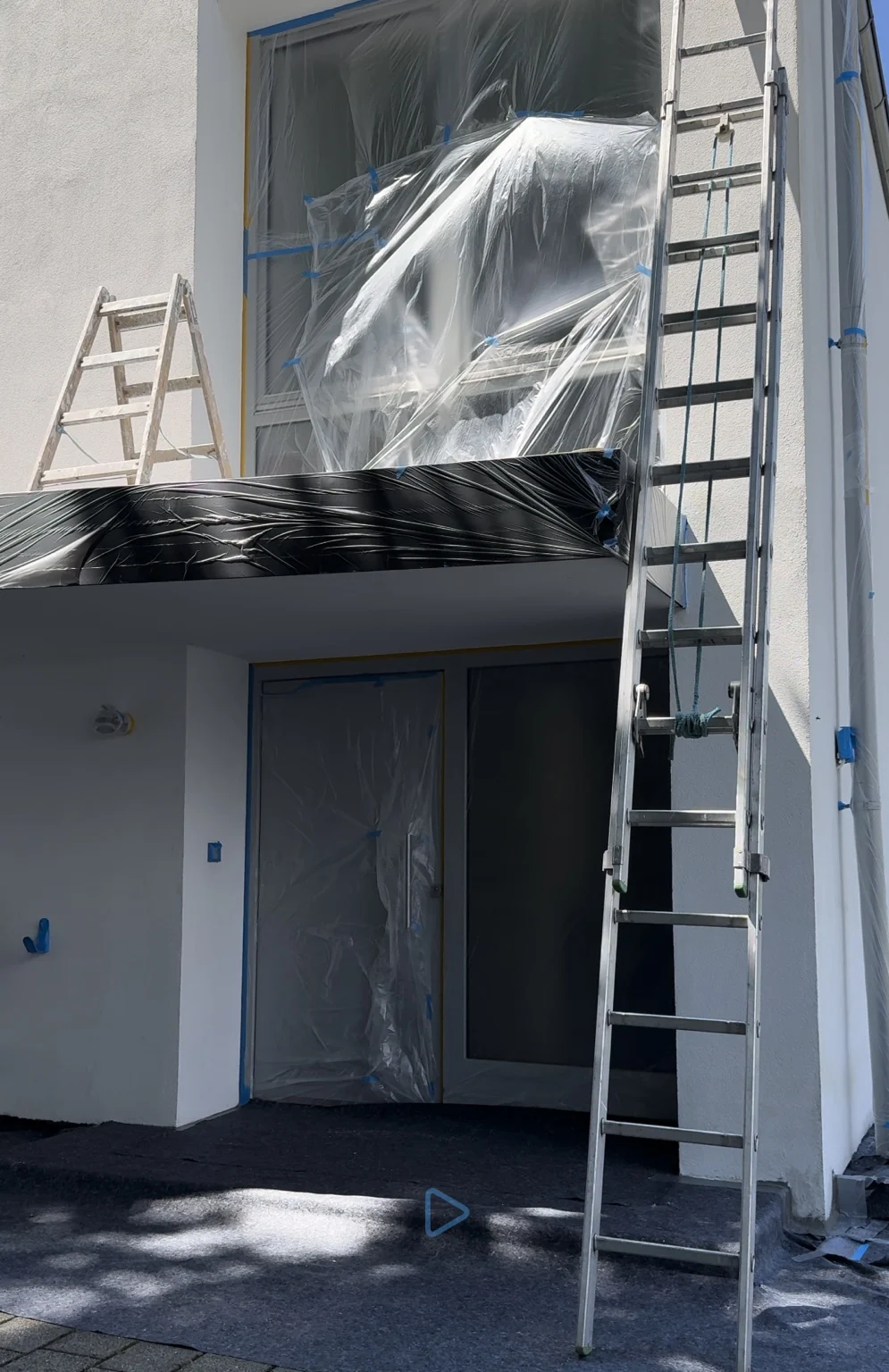 Abgedeckte Fenster und Bauteile während der Fassadenarbeiten