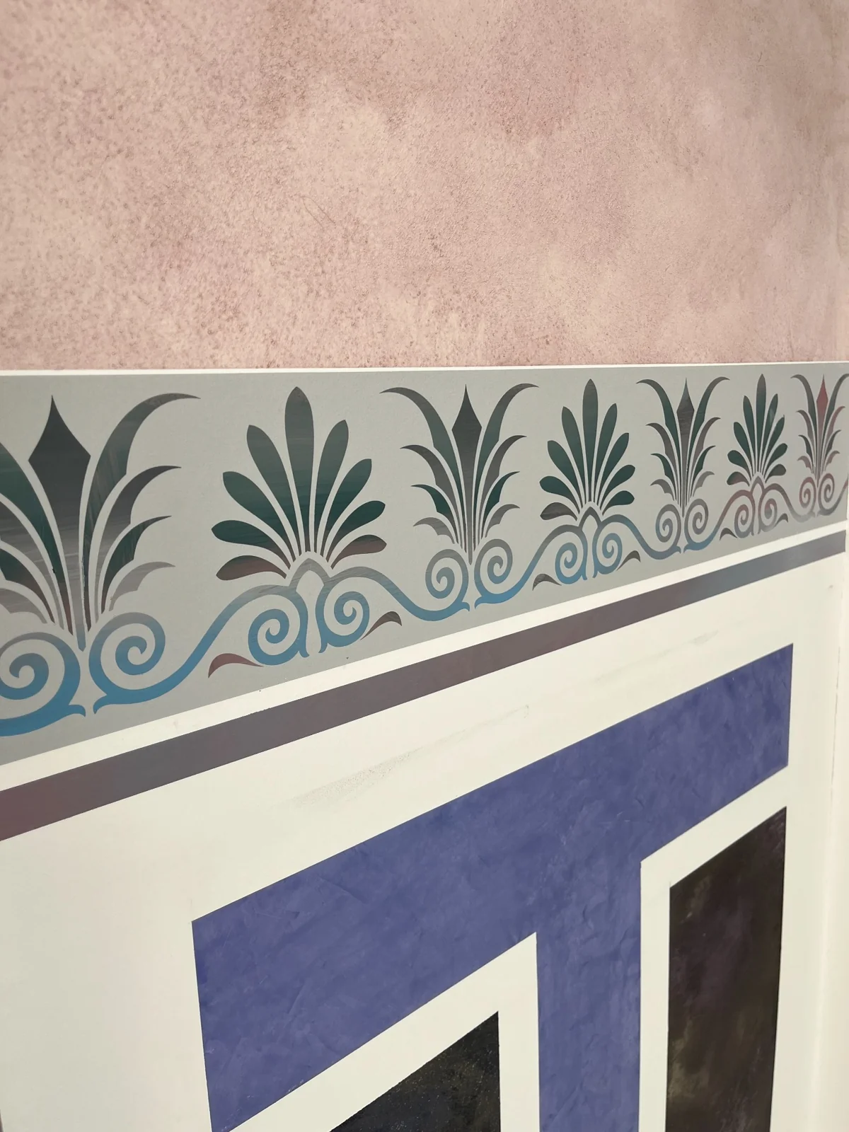 Detail einer dekorativen Musterfläche mit Schablonenbordüre und abgestimmten Farbtönen