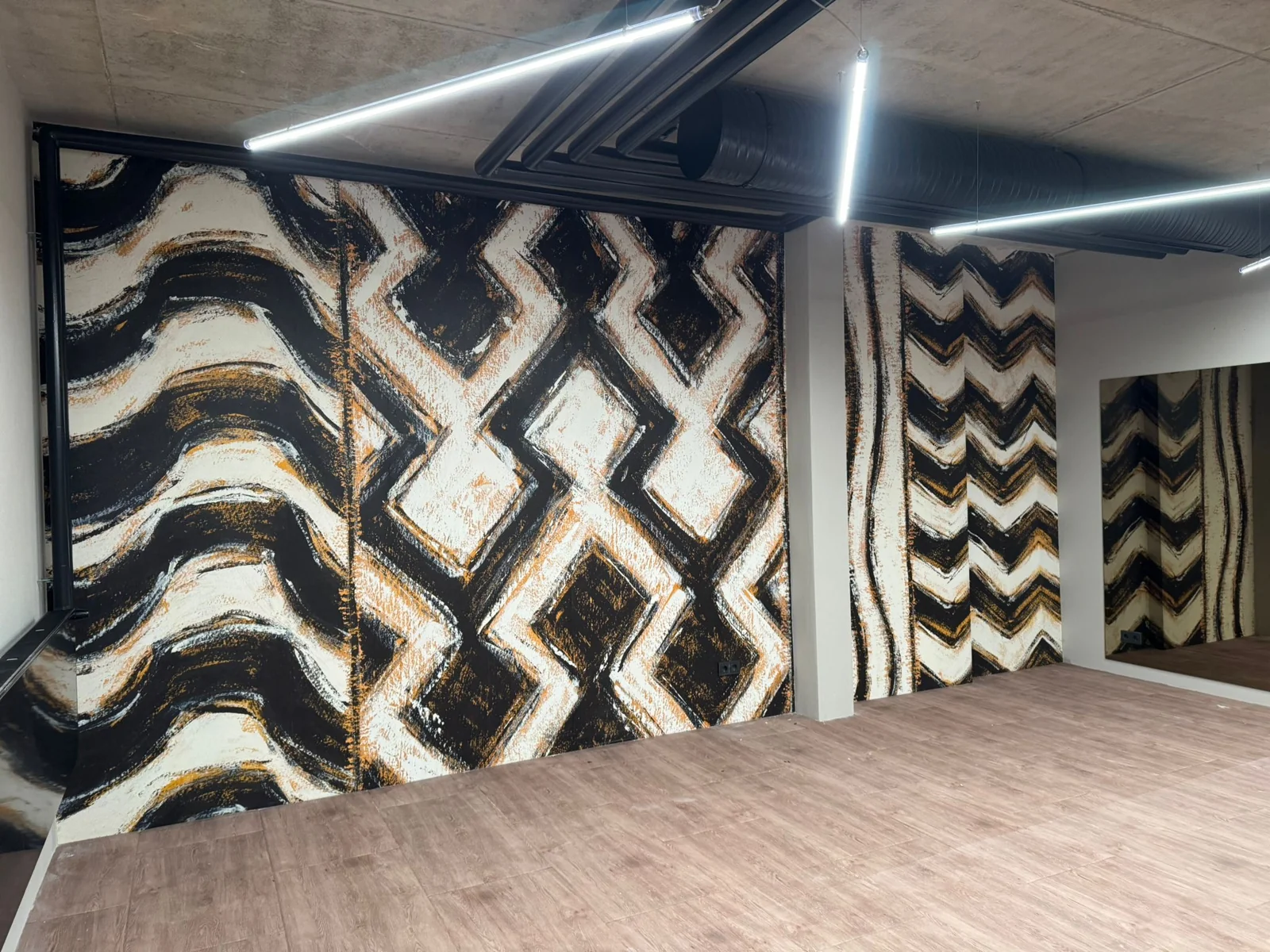 Geometrische Akzentwand in Schwarz, Weiß und Gold als Beispiel individueller Raumgestaltung